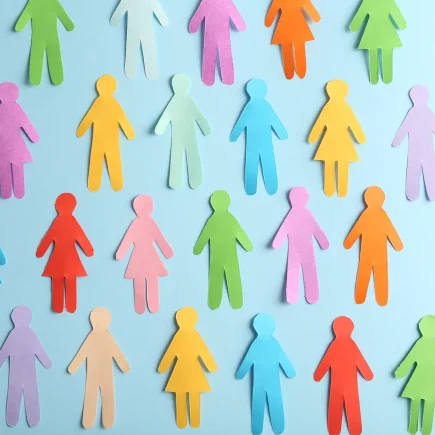 Colorful paper cutouts of people displayed on a blue backdrop