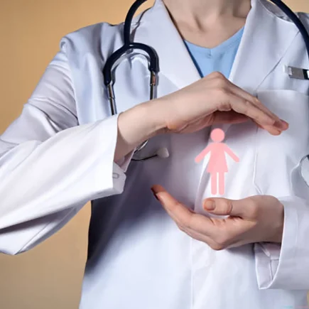 A doctor gently holds a pink heart-shaped figure