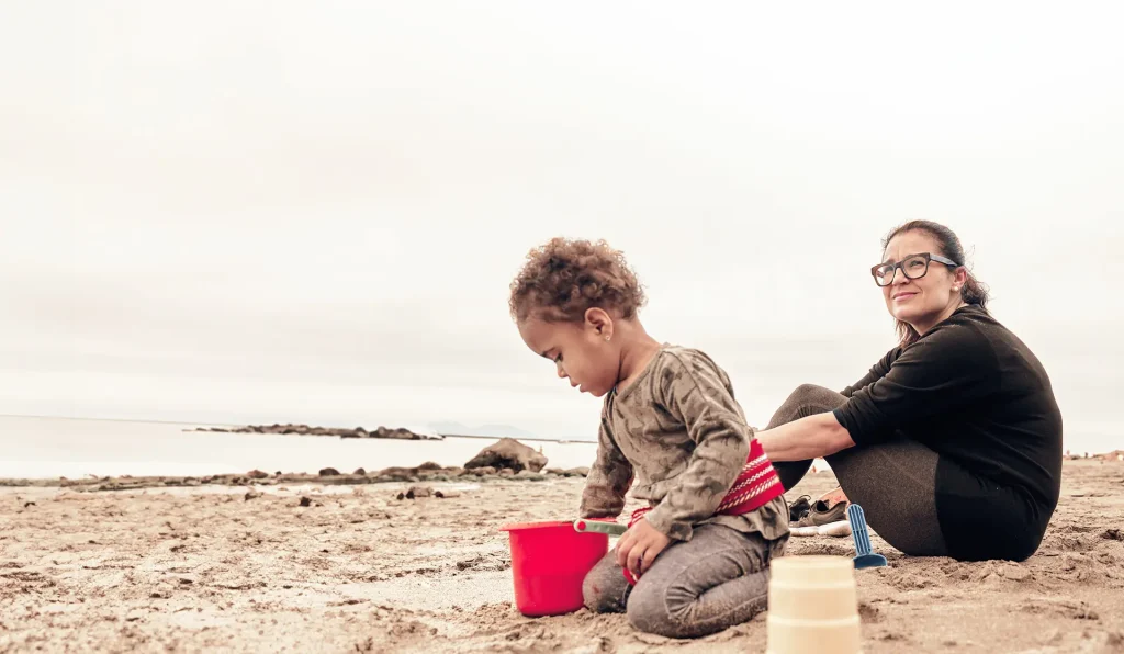 A woman and a child playing on the beach